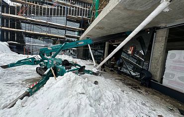 Мини-кран  с вакуумным оборудованием помогает остеклить здание